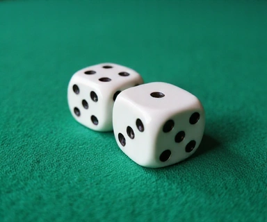 Close-up of a pair of dice showing a winning roll on a green felt table